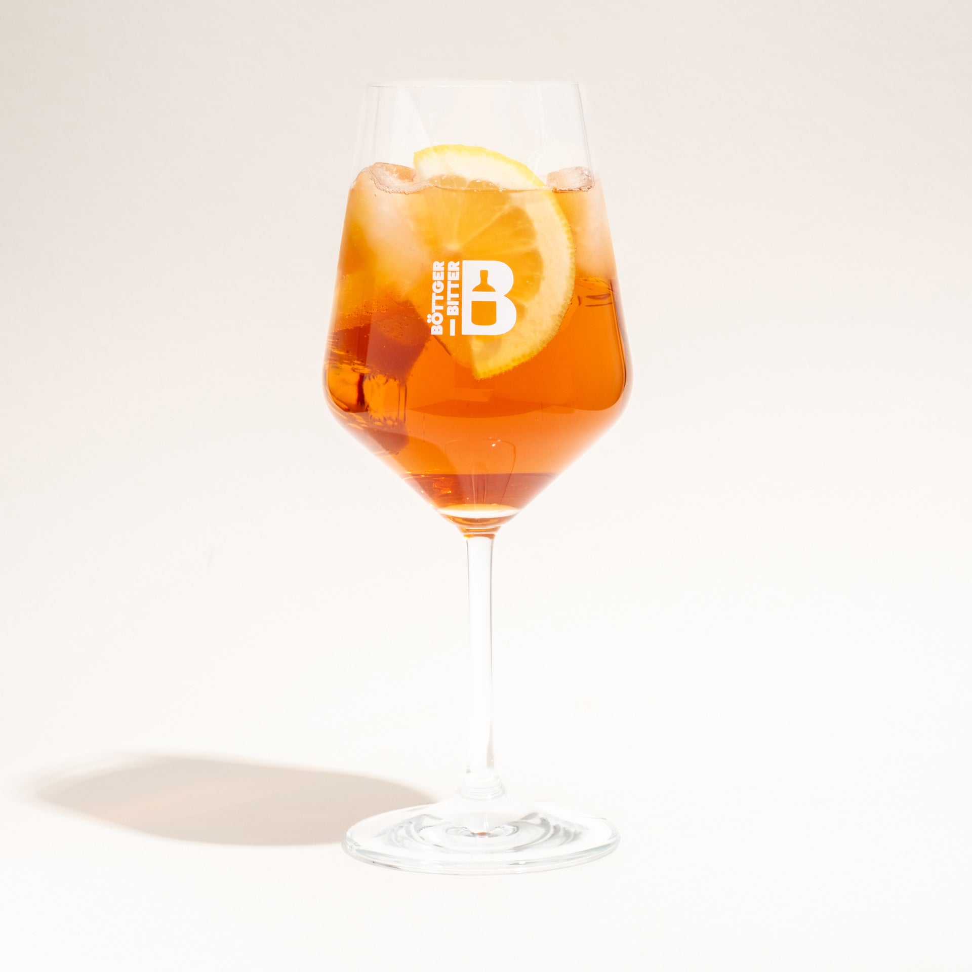 Ein Böttger-Spritz Serviervorschlag im offiziellen Böttger-Logo-Glas mit einer frischen Zitronenscheibe.