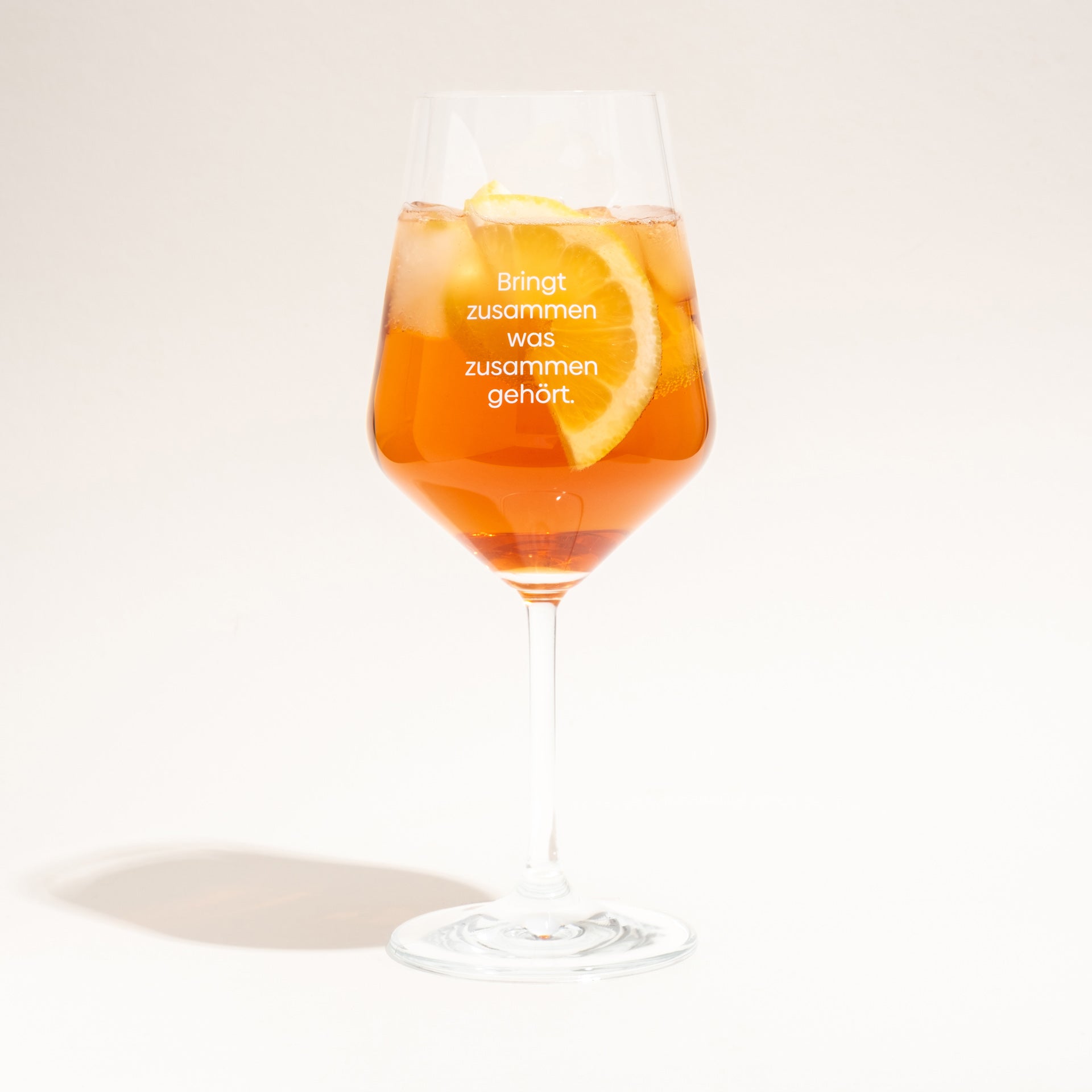 Ein Böttger-Spritz im Glas mit Eis und Zitrone, versehen mit dem weißen Böttger-Schriftzug.