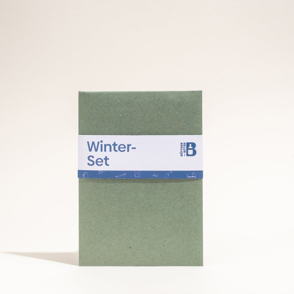 Geschenkverpackung für das "Winter-Set" in Dunkelgrün mit blauem Akzent.
