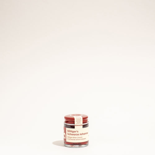 Miniatur-Glas Böttger's Schwarze Johanna Likör mit rotem Deckel und Etikett.